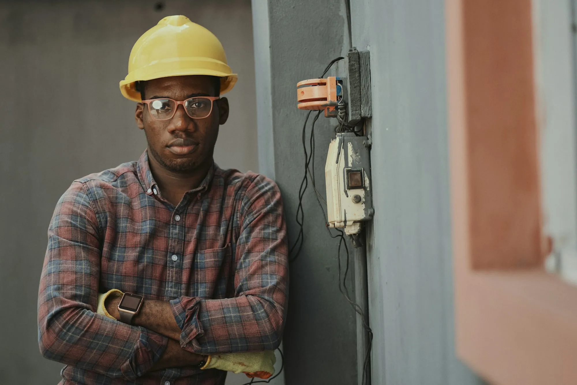 An electrician beside an exterior electrical enclosure