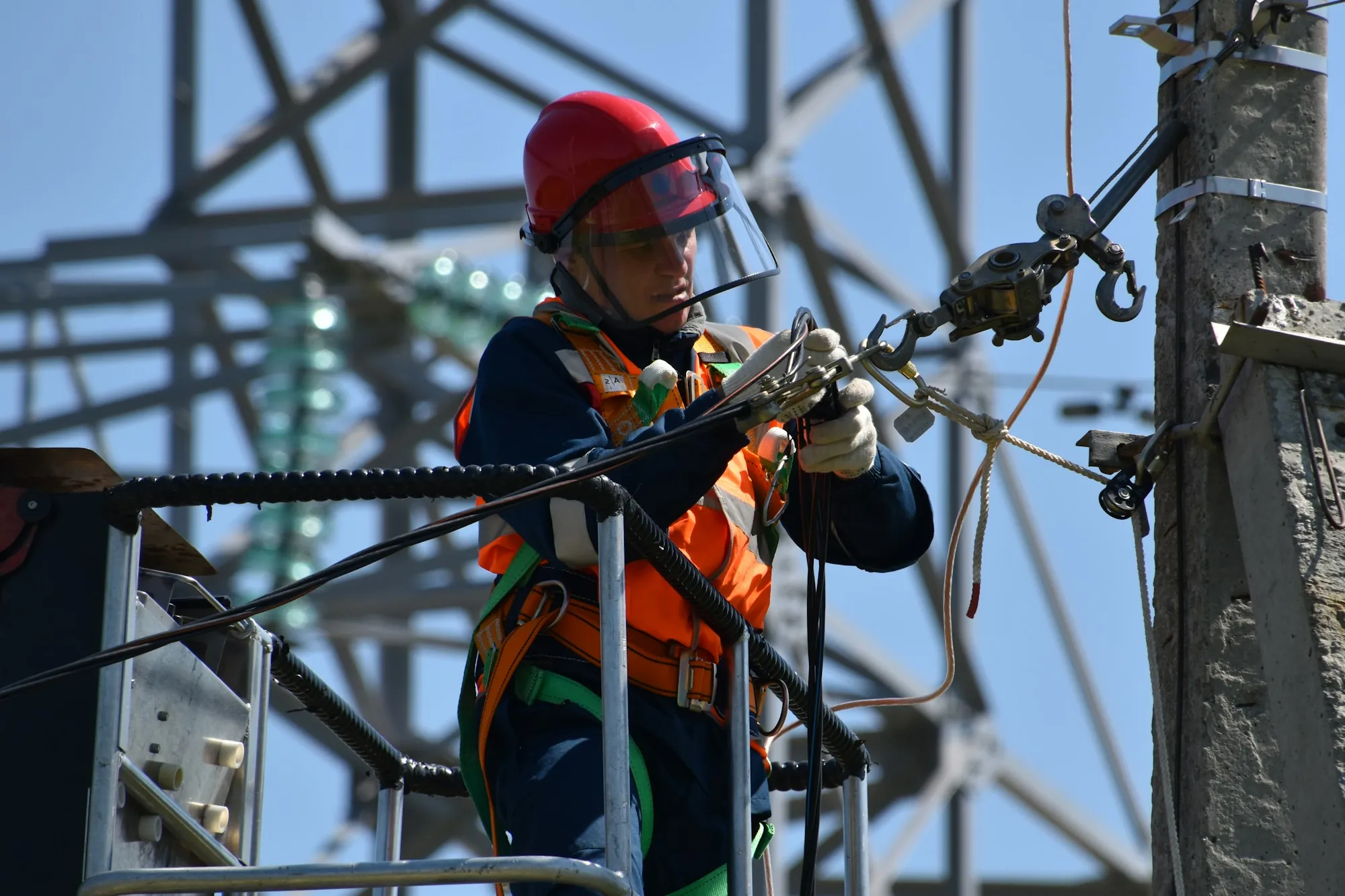 A person on a ladder working on electrical fittings