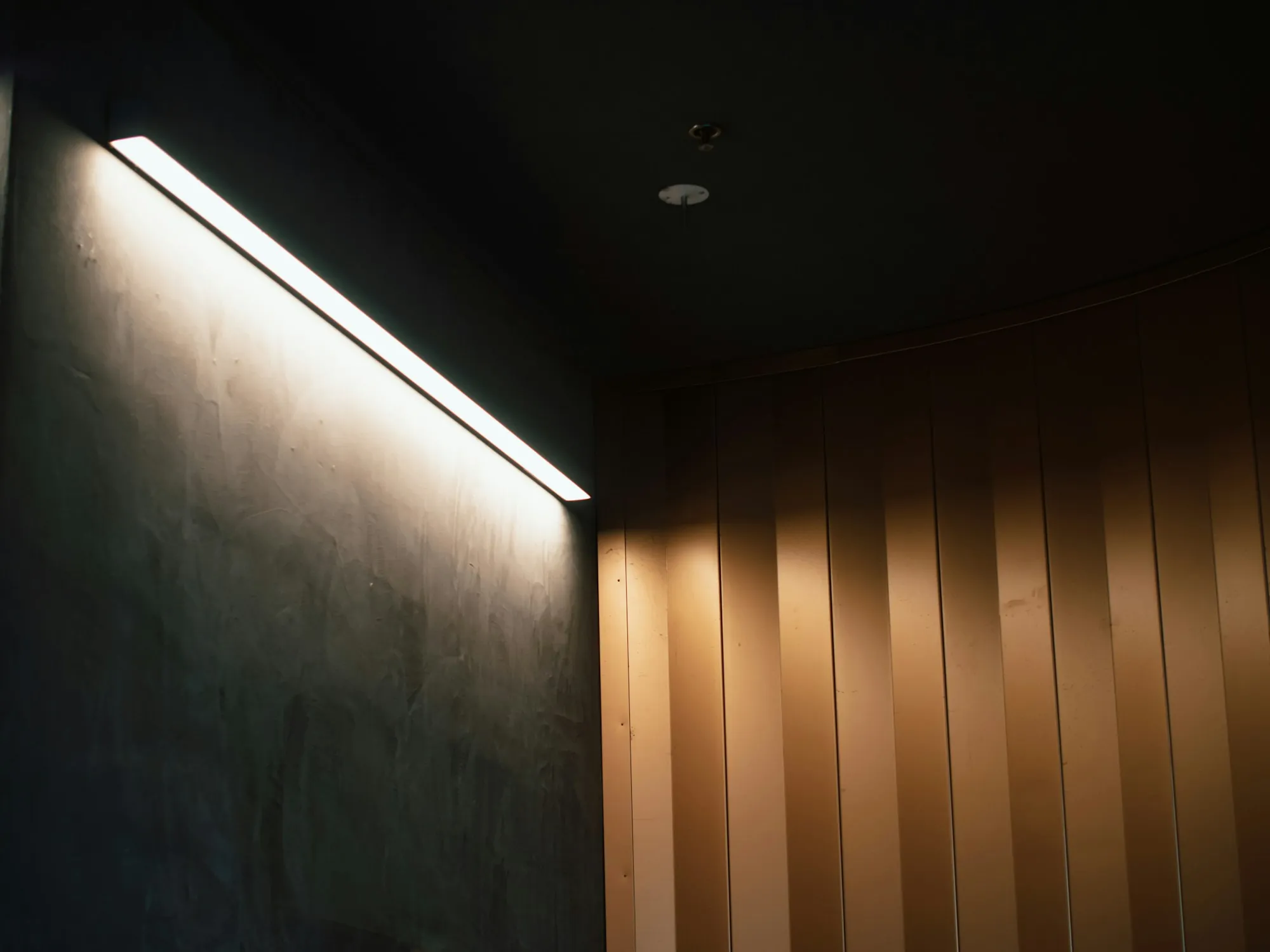 Slim strip light washing a wall with a soft glow