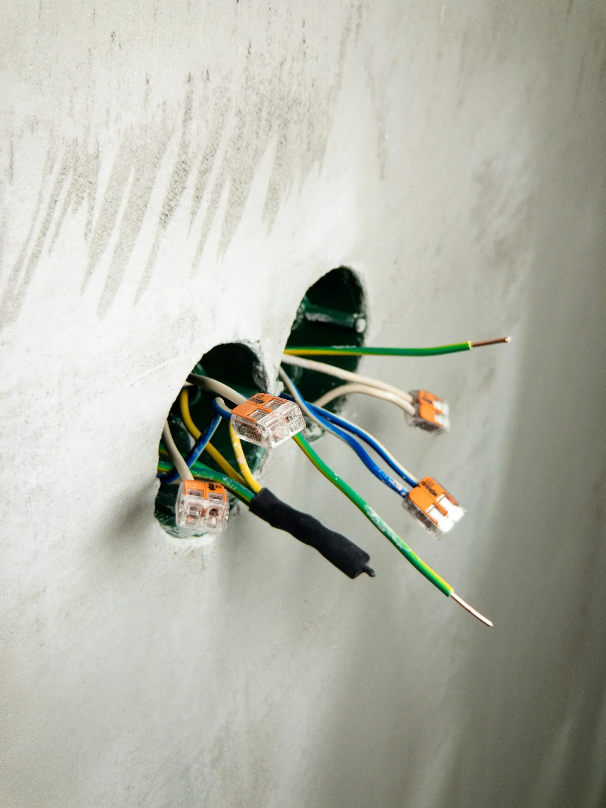 Electrical conductors emerging from an opening in a wall